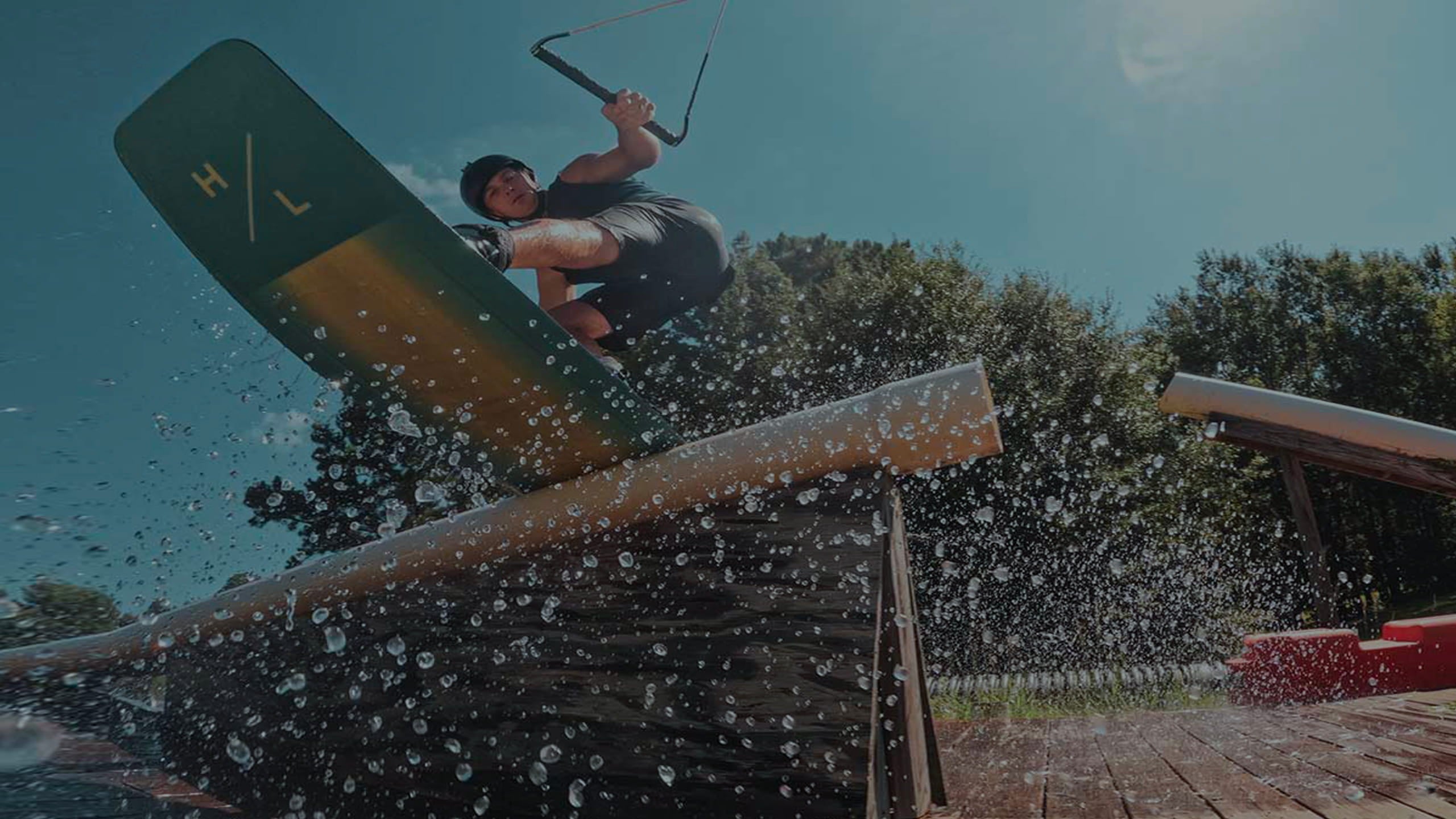 Wakeboardir jibing over the obstacles in cable wakepark.