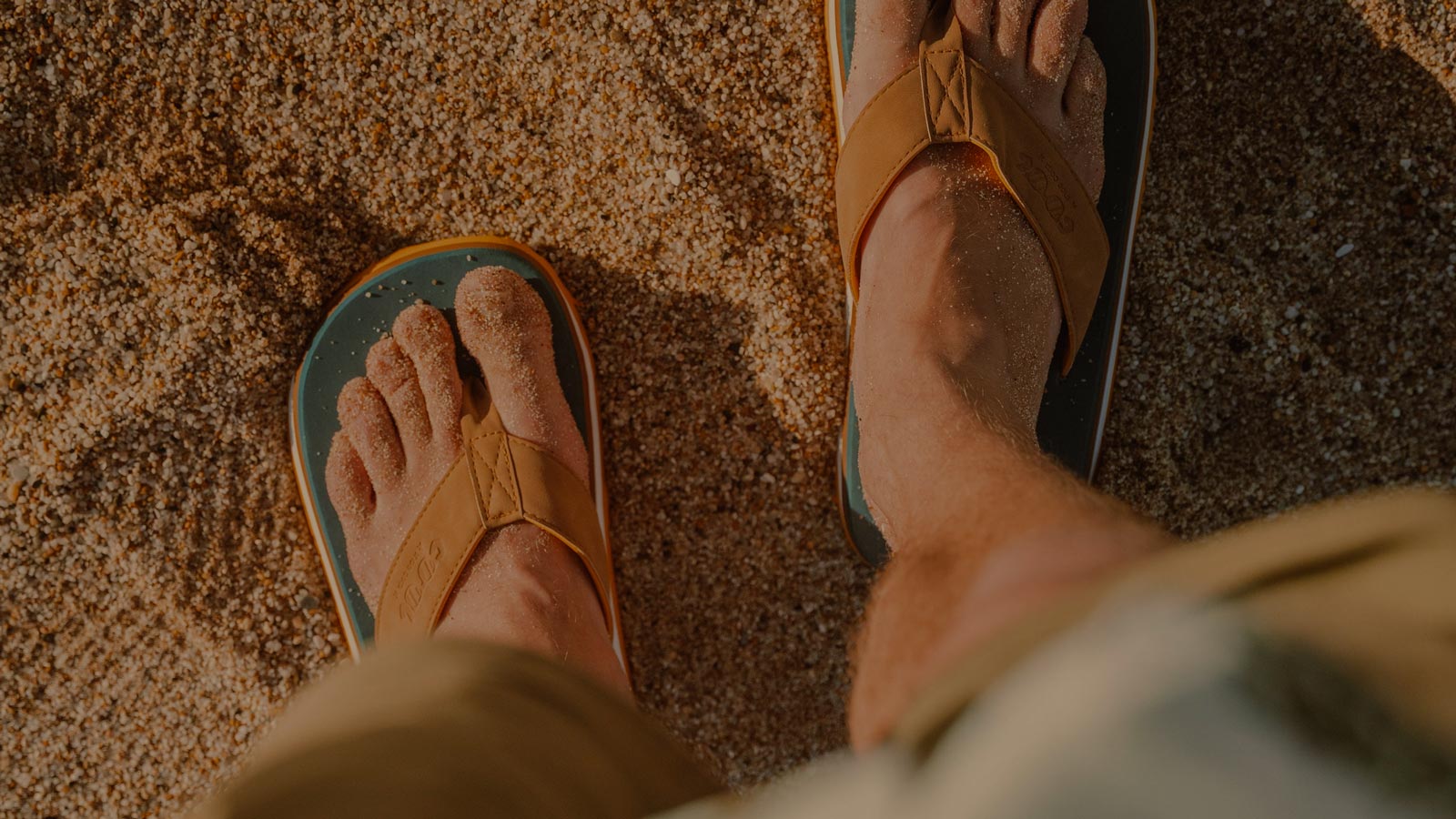 Cool Shoe flip-flops on a sandy beach, built for comfort and laid-back coastal living