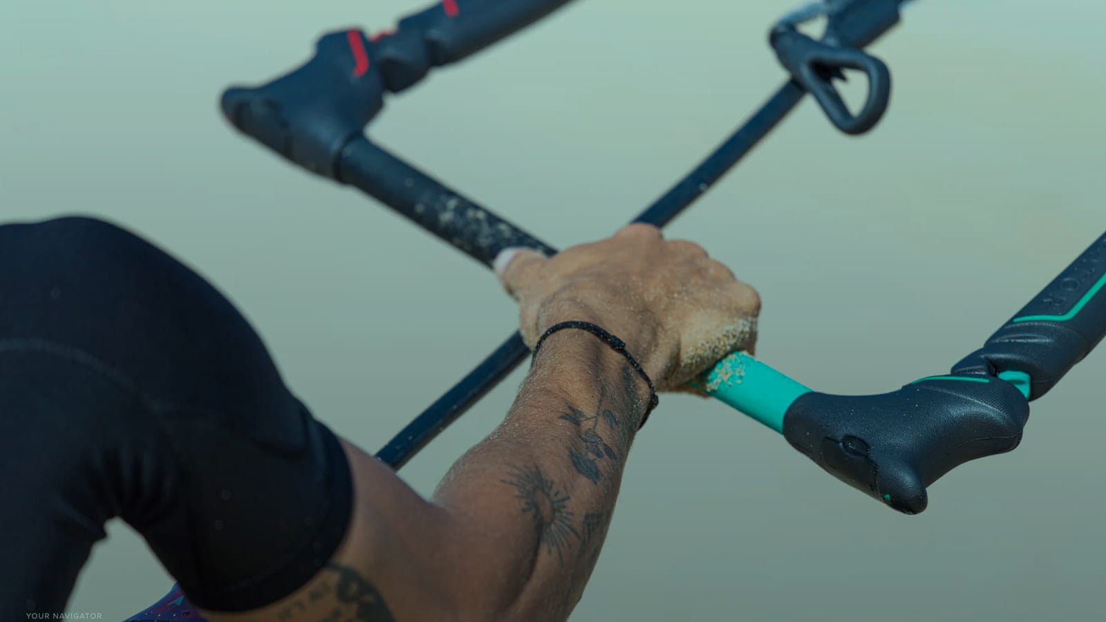 Close-up Kitebloarders hand stearing control bar of the kite.jpg