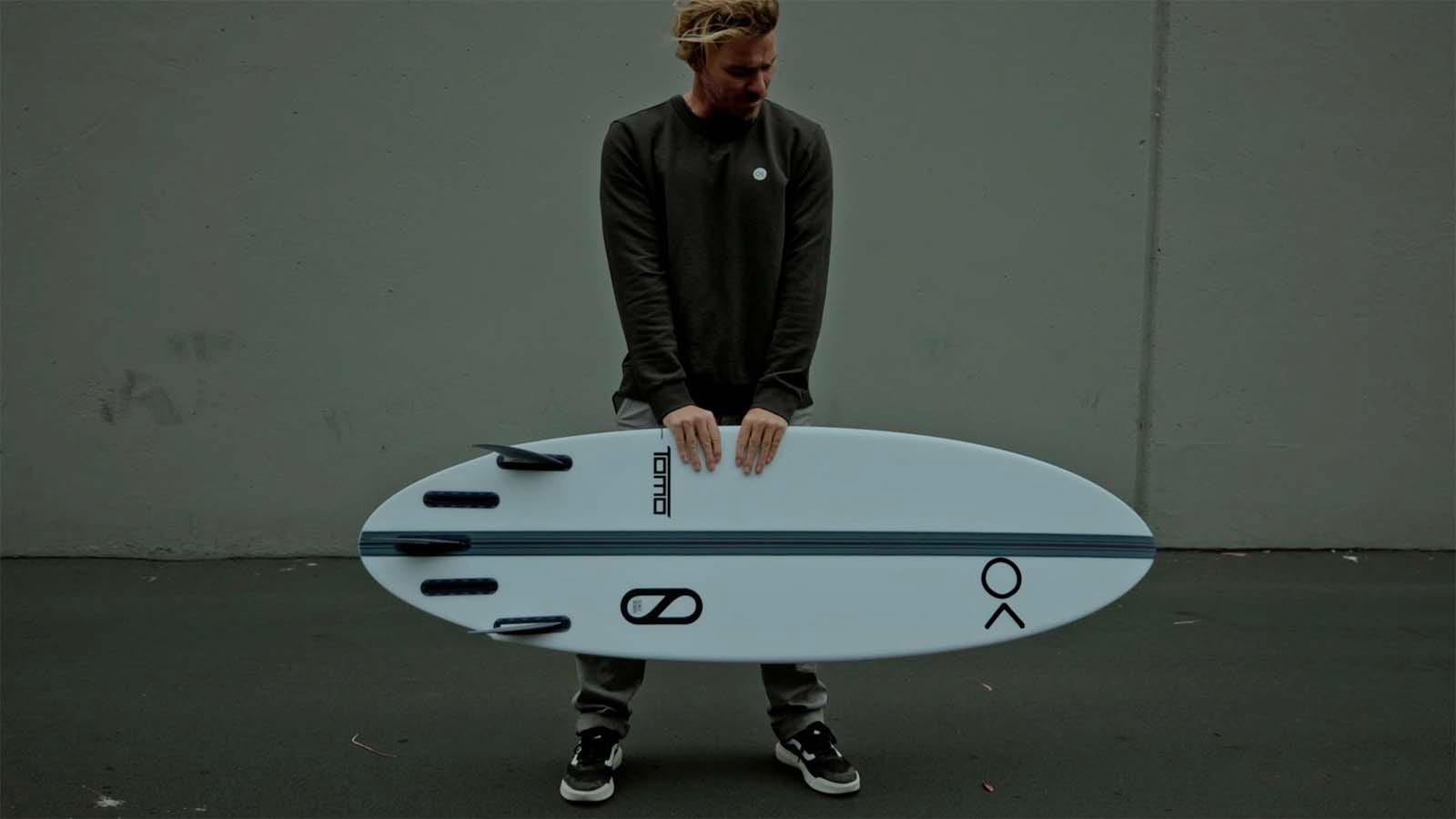 Male holding in hands new surfboard.