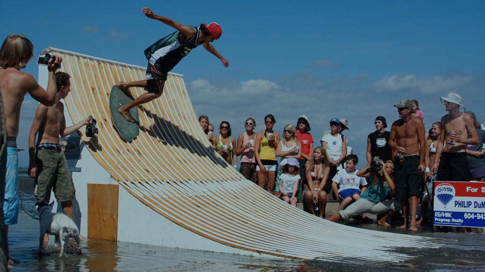 Skimboard Rider Performing a Trick on a Shoreline Ramp