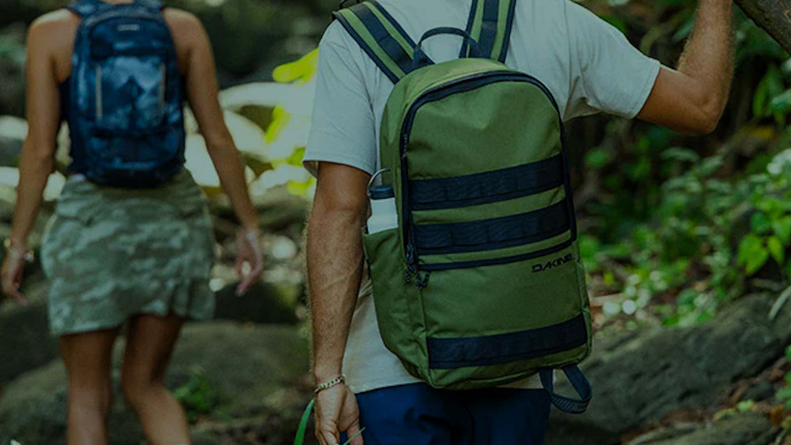 Guy and girl equiped with backpacks exploring forest area. Collection of backpacks, bum bags, board bags, travel bags and wetsuit bags is built for movement.