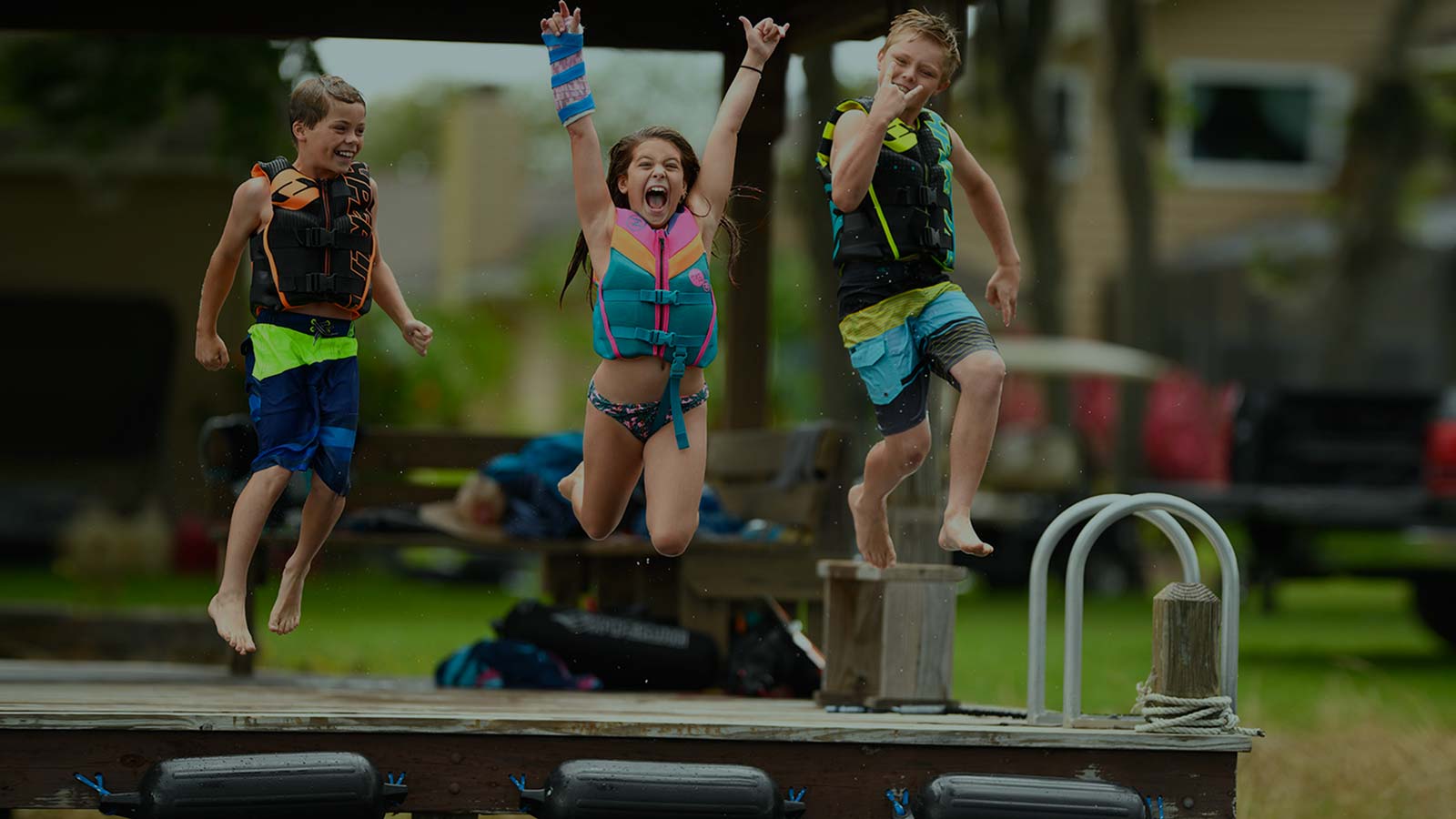 Happy kids jumping from the dock. Life Jackets on. Size options for every age — from baby and toddler life jackets to youth and teen models with sport-specific fits. 