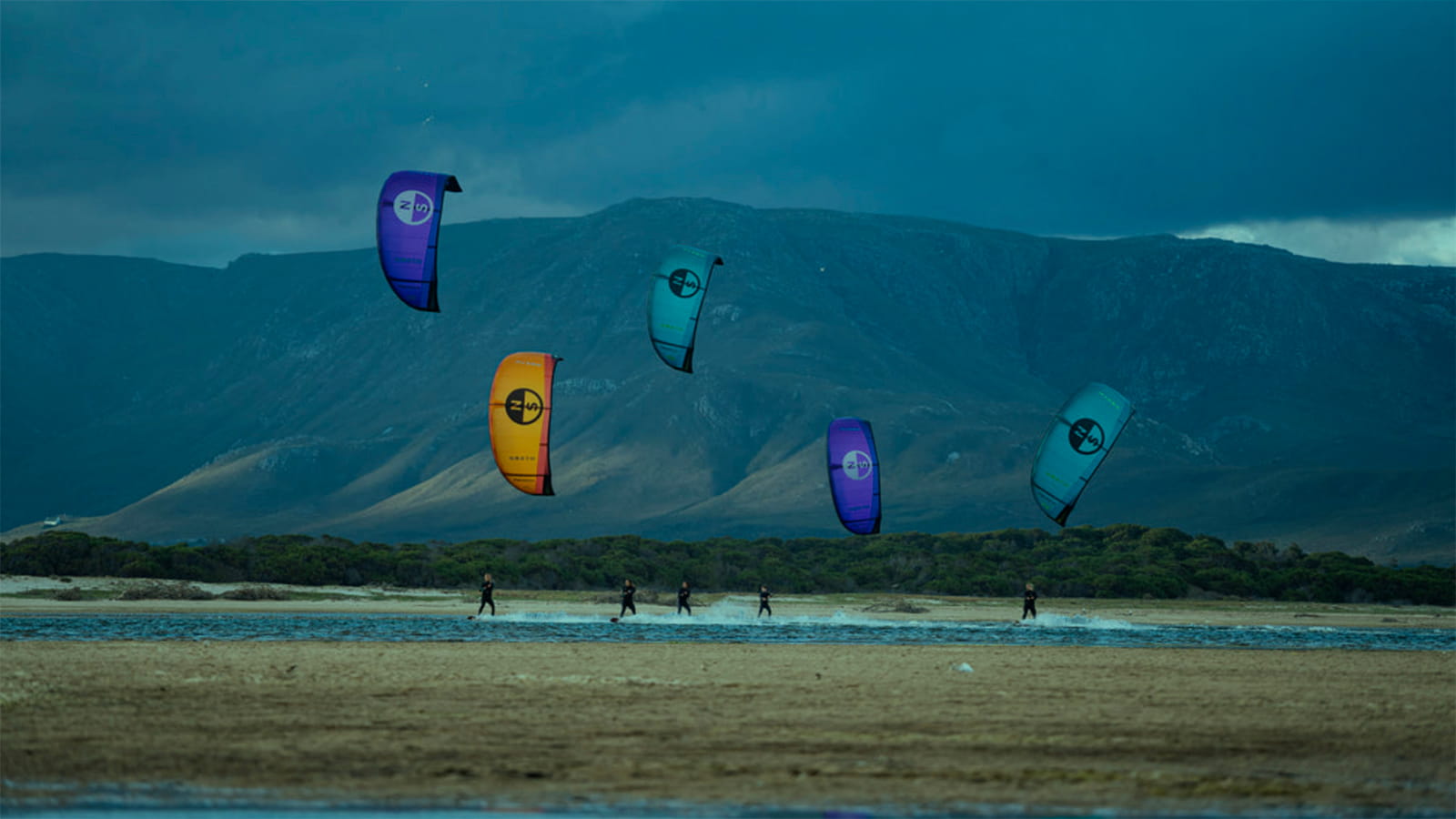 Multiple kitbeoarders chasing wind. Flatwater lagoon.