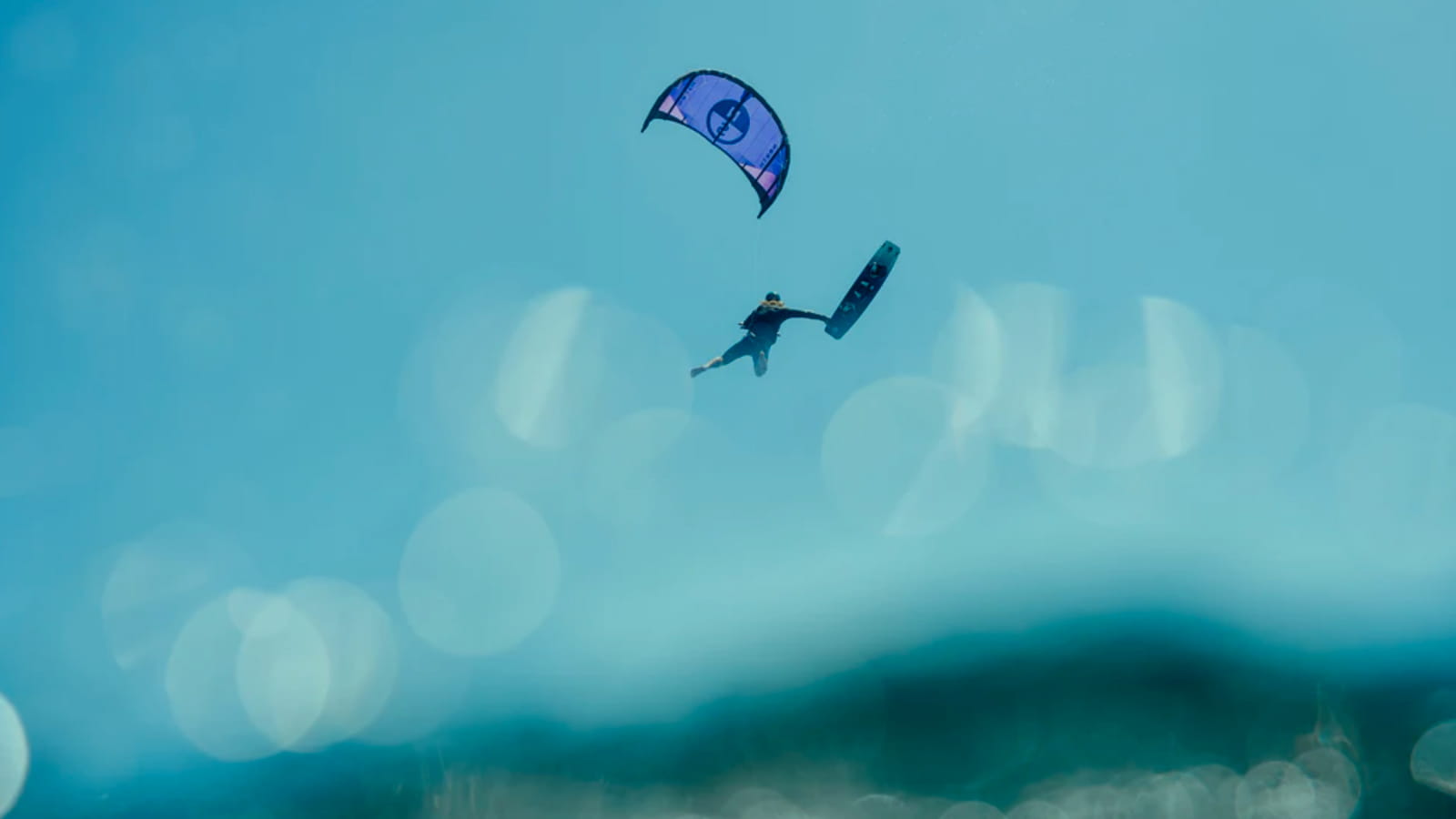 kiteboarder jumping high with a baord off trick.