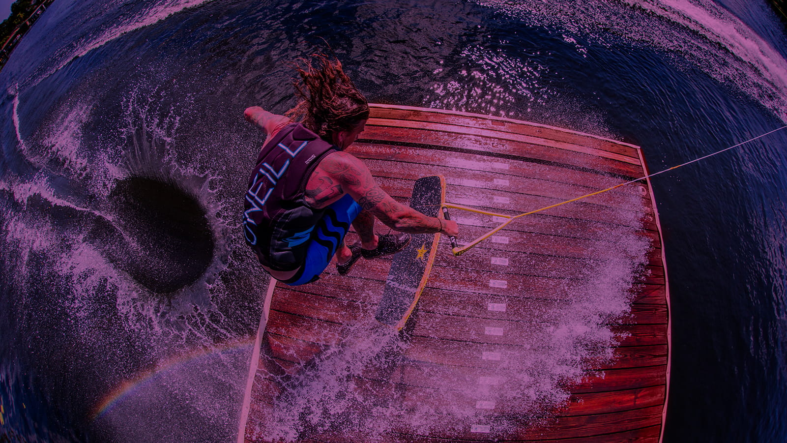 Wakeskater jumping over the dock by getting pulled behind the boat.