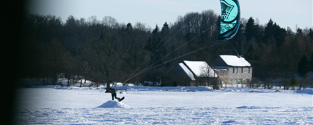 Kaitbords / kaitošana ziemā ar snovbordu pa pļavām un aizsalušiem ezeriem.